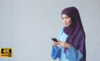 فوتیج ویدیویی زن با حجاب هنگام کار با موبایل