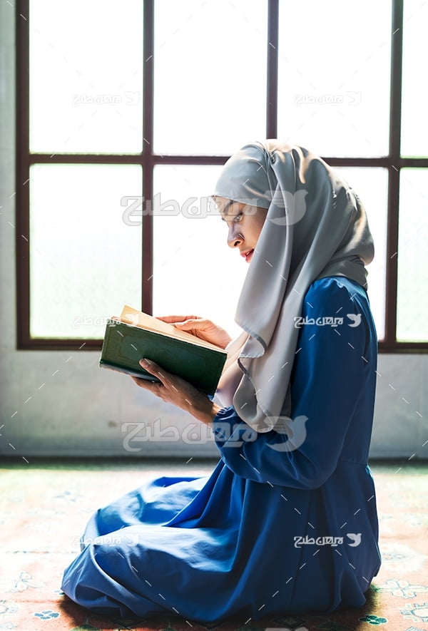 عکس زن با حجاب در حال قرآن خواندن